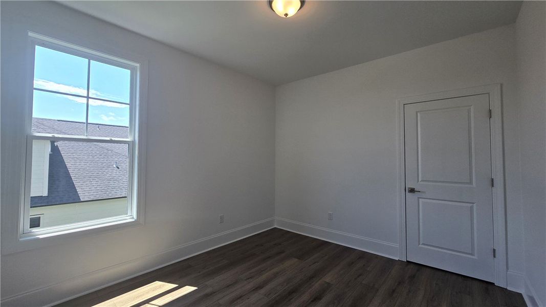 Well-lit room with wood-look flooring and a clean,