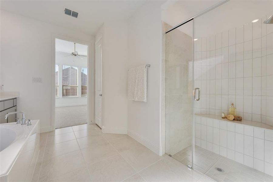 Bathroom featuring tile patterned floors, vanity, separate shower and tub, and ceiling fan