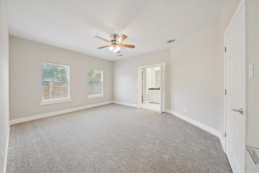 Empty room featuring light colored carpet and ceiling fan