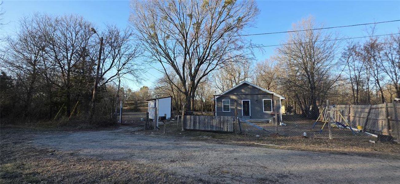 View of front of property with a fenced front yard and a gate