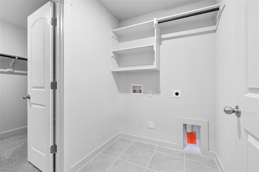Laundry room featuring hookup for an electric dryer, washer hookup, hookup for a gas dryer, and light tile patterned floors