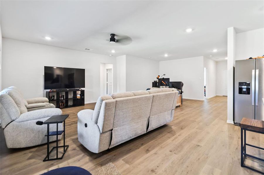 Living area featuring light wood-style flooring, recessed lighting, and a ceiling fan