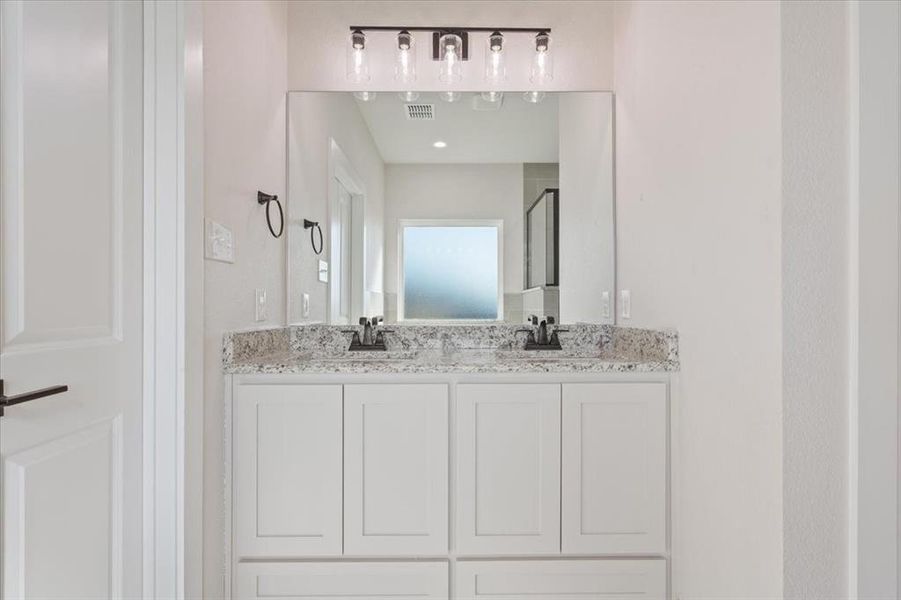 Bathroom featuring a shower stall and double vanity Bathroom featuring a shower stall and double vanity