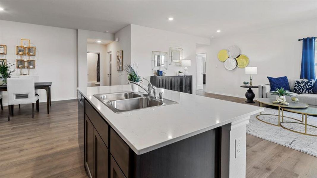 Kitchen with open floor plan, light countertops, dark wood-style flooring, a center island with sink, and recessed lighting