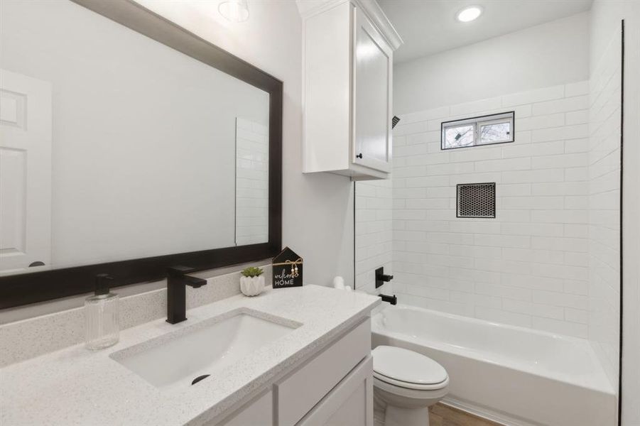 Full bathroom with vanity, toilet, and tiled shower / bath