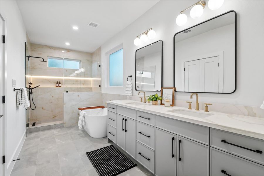 A breathtaking spa-like en-suite bath featuring quartz countertops, dual sinks, a freestanding soaking tub, and a glass-enclosed walk-in shower with designer tile. A breathtaking spa-like en-suite bath featuring quartz countertops, dual sinks, a freestanding soaking tub, and a glass-enclosed walk-in shower with designer tile.