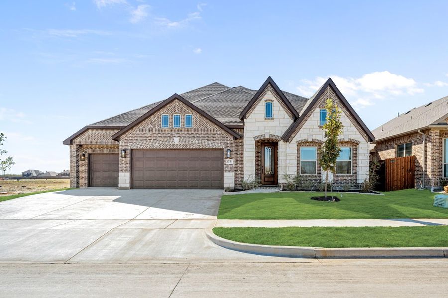 Single-story home with brick and stone exterior, three-car garage, and manicured front lawn Single-story home with brick and stone exterior, three-car garage, and manicured front lawn