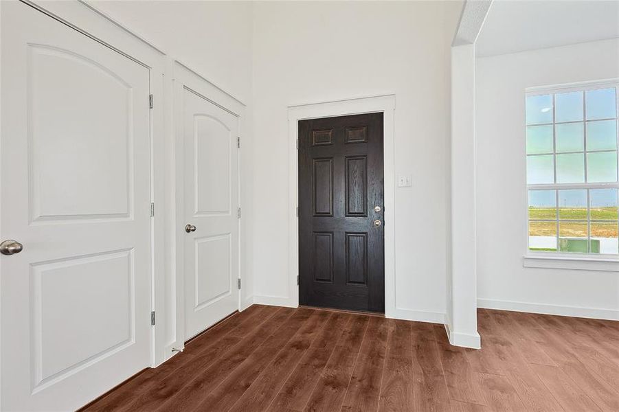 Foyer entrance featuring dark wood-style flooring and baseboards