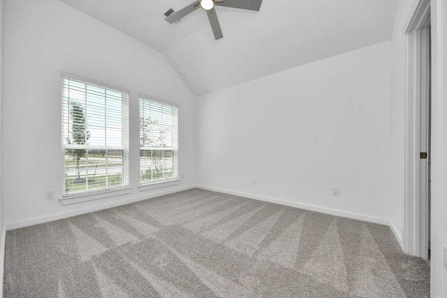 Inviting guest suite. The room features elegant 5-panel doors with sleek, contemporary hardware. Sink your feet into the plush, fluffy carpet that invites comfort and warmth. Large windows flood the space with an abundance of natural light, framed by privacy blinds that offer the perfect balance between openness and seclusion. Sample photo of completed home with similar floor plan. Actual colors and selections may vary.