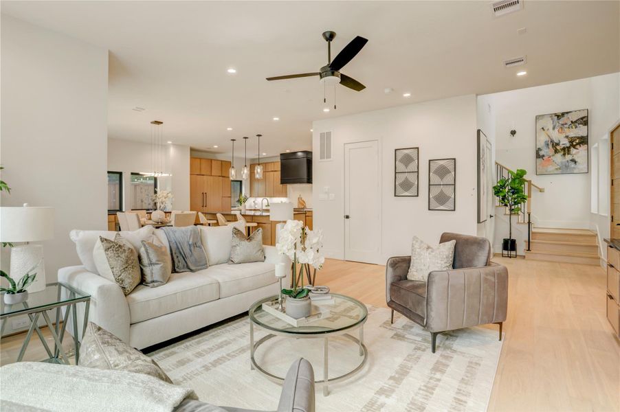 View from the corner of the living room with open views to the entry, dining, and kitchen, as well as windows surrounding the whole property.