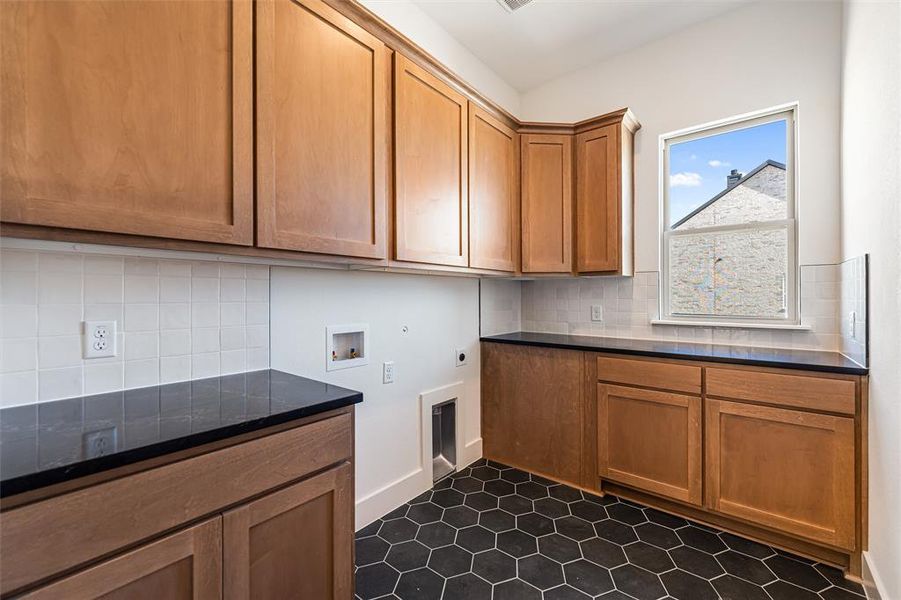 Washroom featuring hookup for a washing machine, electric dryer hookup, and cabinet space