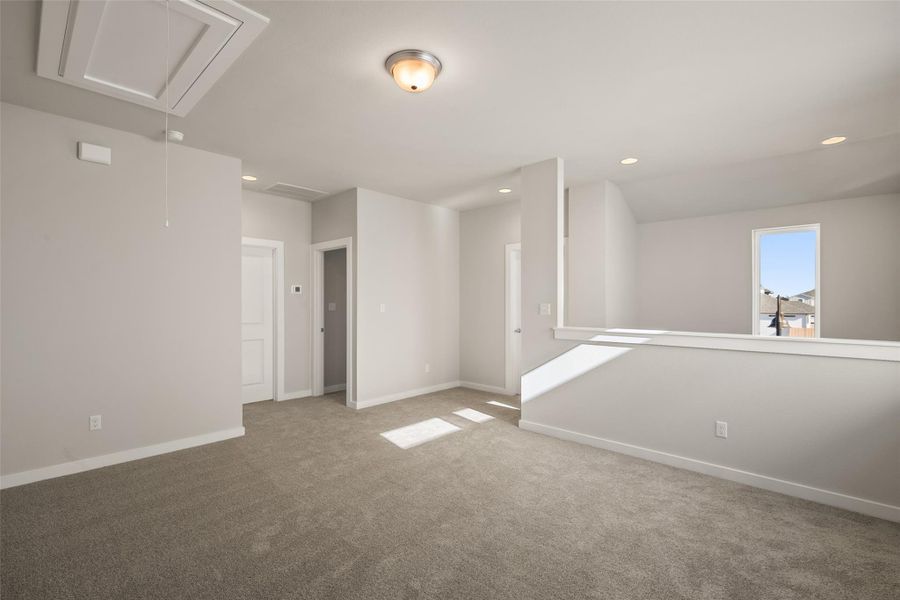Carpeted spare room with attic access and recessed lighting
