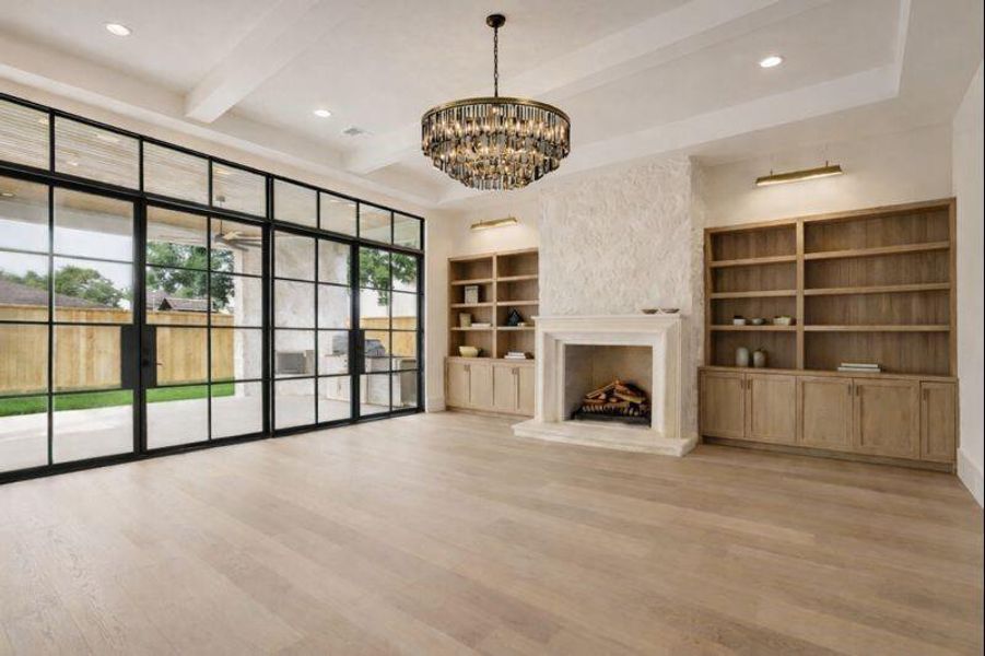 Living room features custom fireplace with built-ins, massive glass doors overlooking the large covered patio   *this photo has been virtually rendered based on a previous home constructed by the builder. 1519 Candlelight may have different selections at builders sole discretion. These photos are not meant to be an exact representation of 1519 Candlelight.