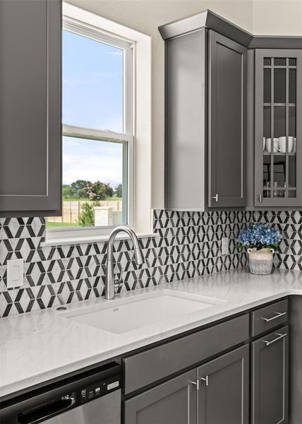 Kitchen featuring gray cabinetry, white countertops, and a patterned tile backsplash