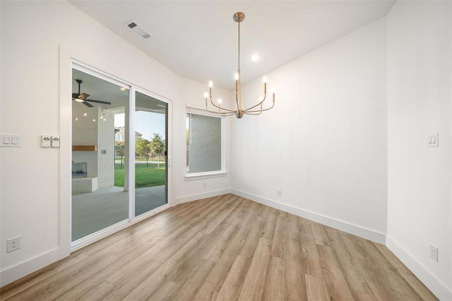 Unfurnished room featuring light wood finished floors, a chandelier, and recessed lighting
