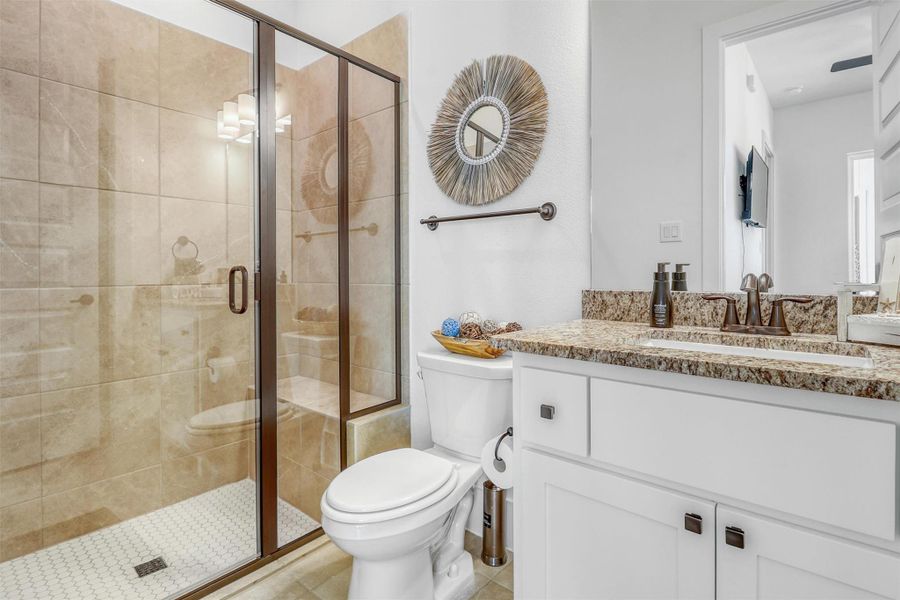 Casita bathroom features a step-in shower for easy accessibility, tile flooring, vanity, granite countertops, and under mount sink.