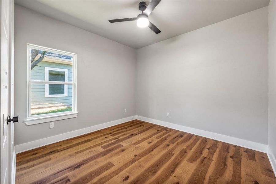 Spare room featuring wood finished floors and a ceiling fan Spare room featuring wood finished floors and a ceiling fan