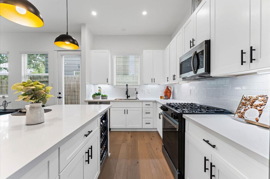 This stylish kitchen showcases plenty of sleek cabinetry, thoughtfully arranged to maximize storage and enhance the room’s modern aesthetic. Upper and lower cabinets feature clean lines and minimalist hardware, blending seamlessly with the space’s design. Integrated appliances and under-cabinet lighting add both function and flair, while the layout easy access and efficient organization. Ideal for culinary enthusiasts and entertainers alike, this kitchen combines smart storage with sophisticated style.
