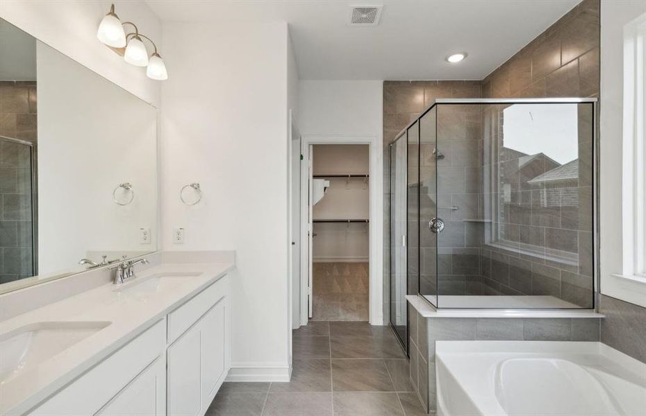 Elegant owner's bathroom with dual vanity *real home pictured