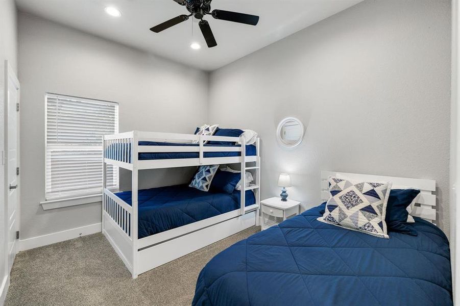 Carpeted bedroom featuring ceiling fan and recessed lighting