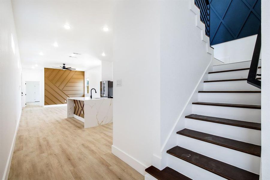 Stairs featuring a ceiling fan, wood finished floors, and recessed lighting