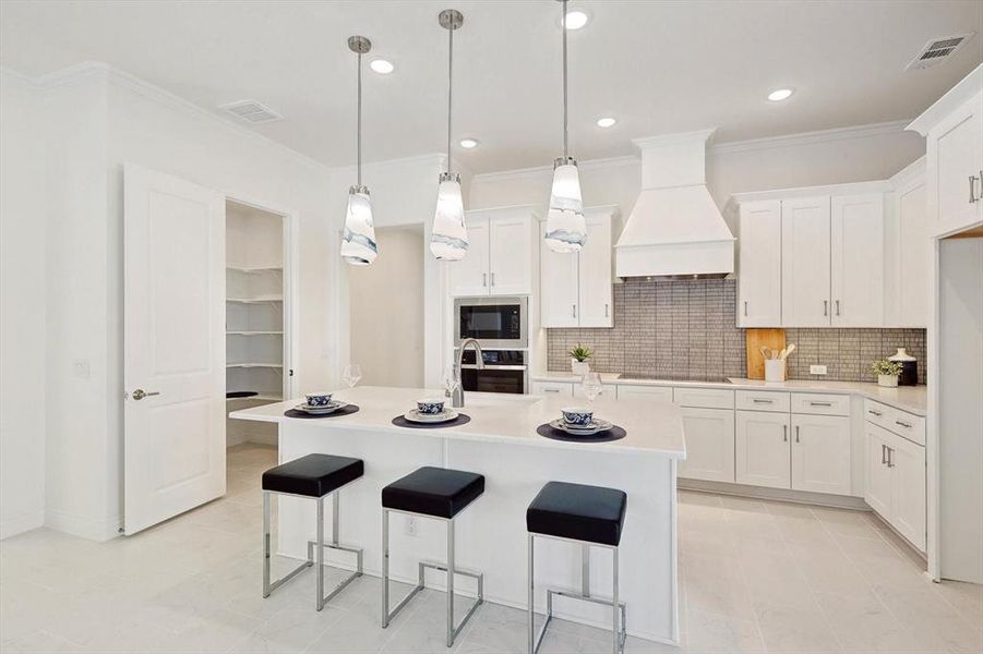 Kitchen featuring white cabinetry, premium range hood, backsplash, pendant lighting, and stainless steel oven