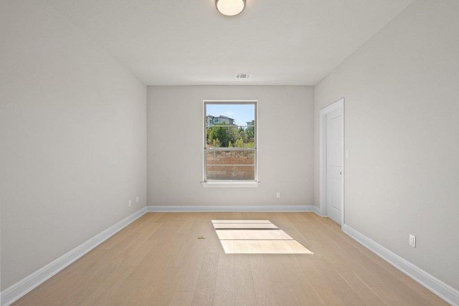 The 5th bedroom features wood floors that could serve as a second office or fitness space.