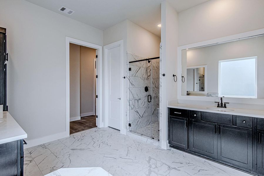 Spacious en-suite bath with dual sinks and elegant finishes Spacious en-suite bath with dual sinks and elegant finishes