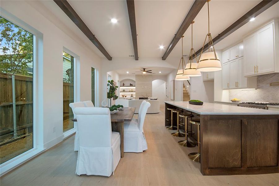 Dining room with arched walkways, light wood-type flooring, ceiling fan, stairway, and recessed lighting