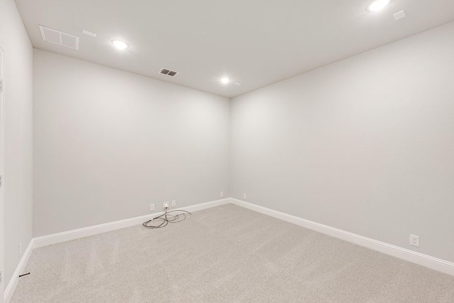 Empty room with light gray carpet, white walls, and recessed ceiling lights Empty room with light gray carpet, white walls, and recessed ceiling lights