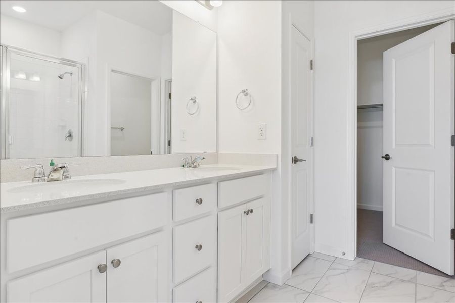 A bathroom with white cabinets.