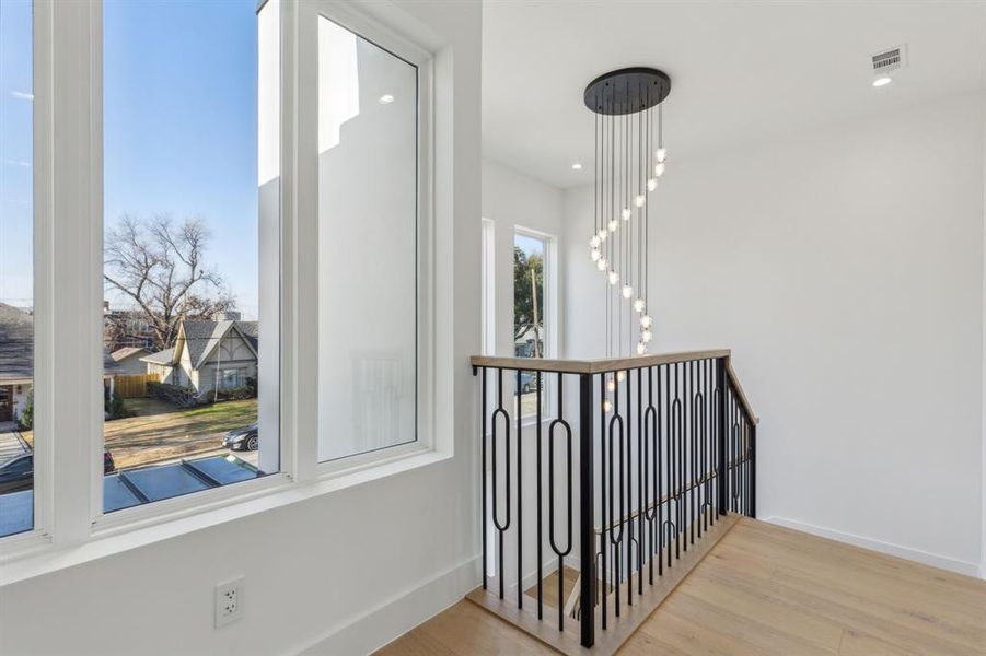 Corridor with a notable chandelier and light hardwood / wood-style flooring