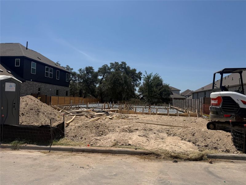An empty residential lot sits ready for development under clear blue skies.