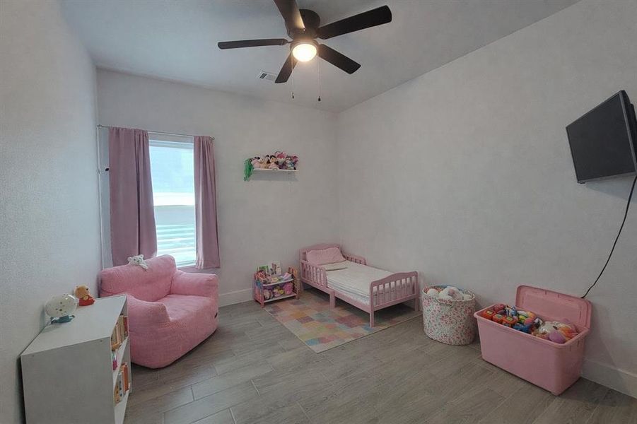 Bedroom with wood finished floors and ceiling fan Bedroom with wood finished floors and ceiling fan