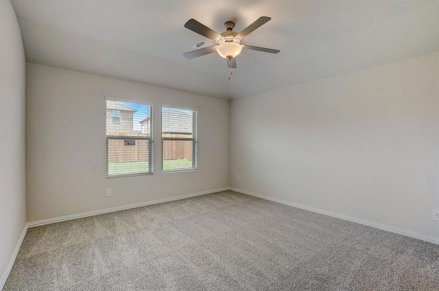 Carpeted spare room featuring ceiling fan