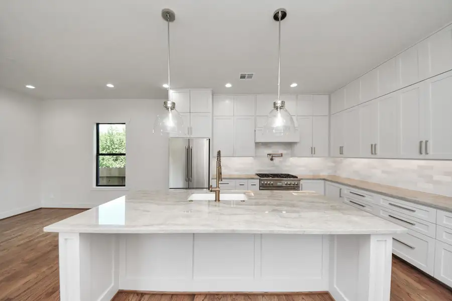 The kitchen backsplash maintains a sleek, uninterrupted look thanks to thoughtfully placed outlets hidden beneath the cabinetry. Undercabinet lighting enhances both function and ambiance, casting a warm glow across the custom tilework The kitchen backsplash maintains a sleek, uninterrupted look thanks to thoughtfully placed outlets hidden beneath the cabinetry. Undercabinet lighting enhances both function and ambiance, casting a warm glow across the custom tilework