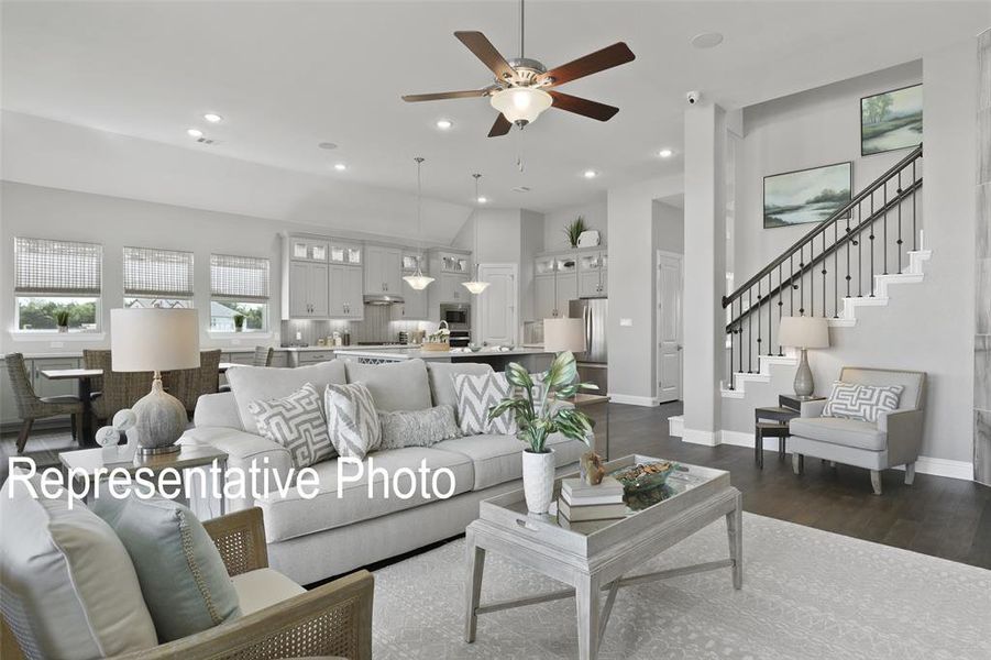 Open-concept living area featuring dark wood-finish flooring, recessed lighting, and a contemporary ceiling fan Open-concept living area featuring dark wood-finish flooring, recessed lighting, and a contemporary ceiling fan