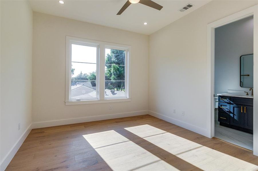 Unfurnished room with light wood-type flooring, ceiling fan, and sink