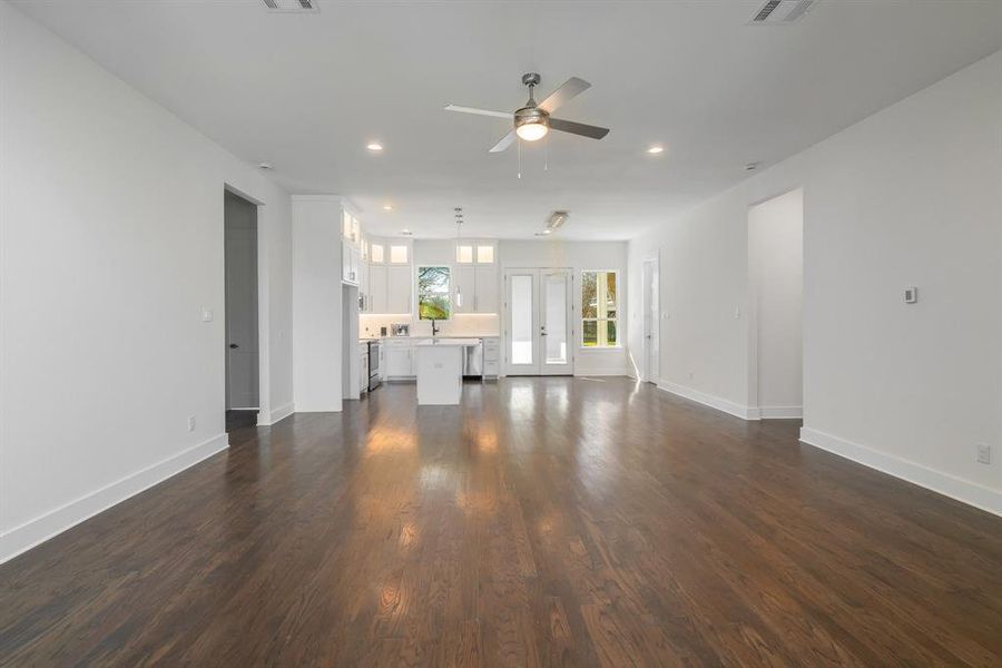 Unfurnished living room featuring sink, french doors, ceiling fan, and hardwood / wood-style floors