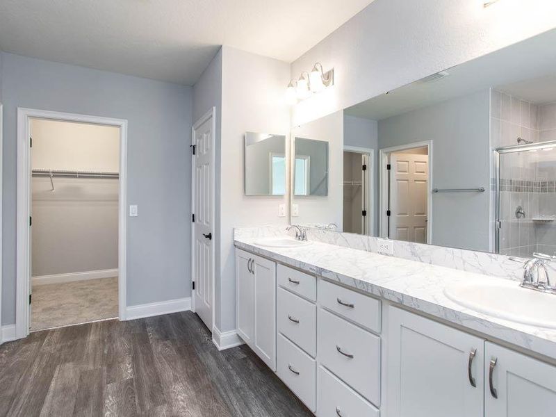 En-suite owner`s bath with dual vanities, ample cabinet/drawer space, a tiled shower, linen closet, and private toilet - Wayfair by Highland Homes