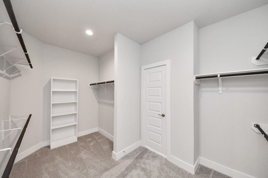 Walk-in closet that epitomizes luxury and practicality. This generously sized space features built-in shelving, offering abundant room for impeccable organization. High ceilings and recessed lighting create a bright and welcoming ambiance. Walk-in closet that epitomizes luxury and practicality. This generously sized space features built-in shelving, offering abundant room for impeccable organization. High ceilings and recessed lighting create a bright and welcoming ambiance.