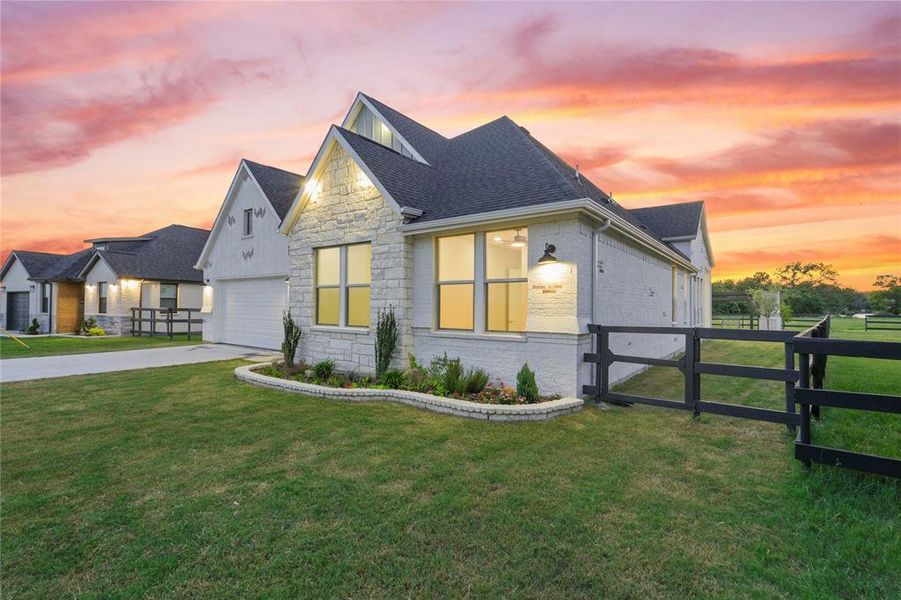 View of front of home featuring a shingled roof, brick siding, stone siding, and driveway View of front of home featuring a shingled roof, brick siding, stone siding, and driveway