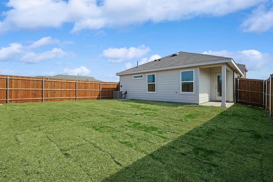 Back of property with a lawn and central air condition unit