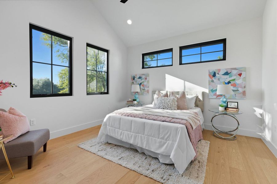 Bedroom featuring light wood finished floors, recessed lighting, ceiling fan, and high vaulted ceiling