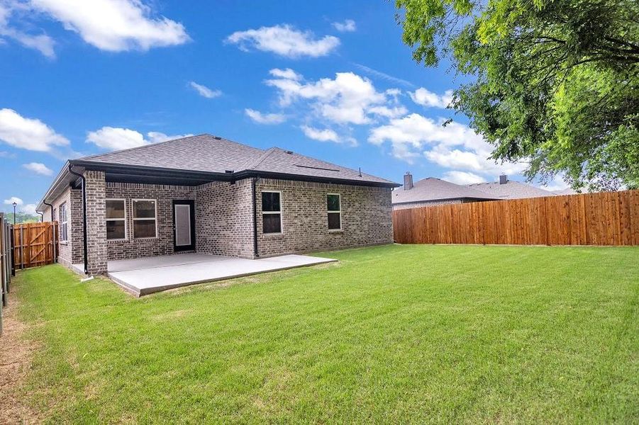 Rear view of house featuring a patio area, brick siding, and a shingled roof Rear view of house featuring a patio area, brick siding, and a shingled roof