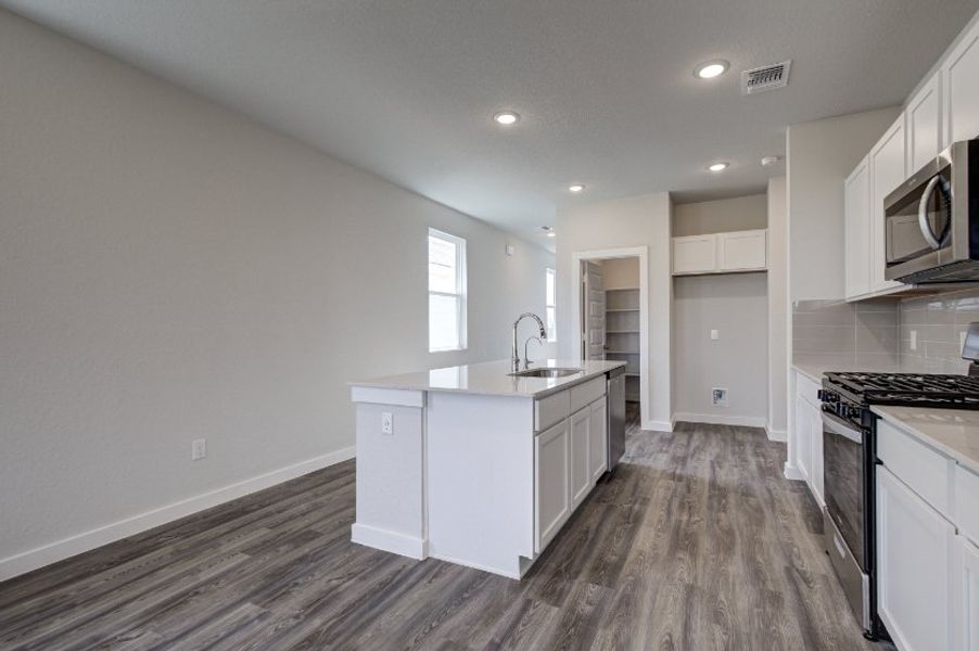 A kitchen with white cabinets.