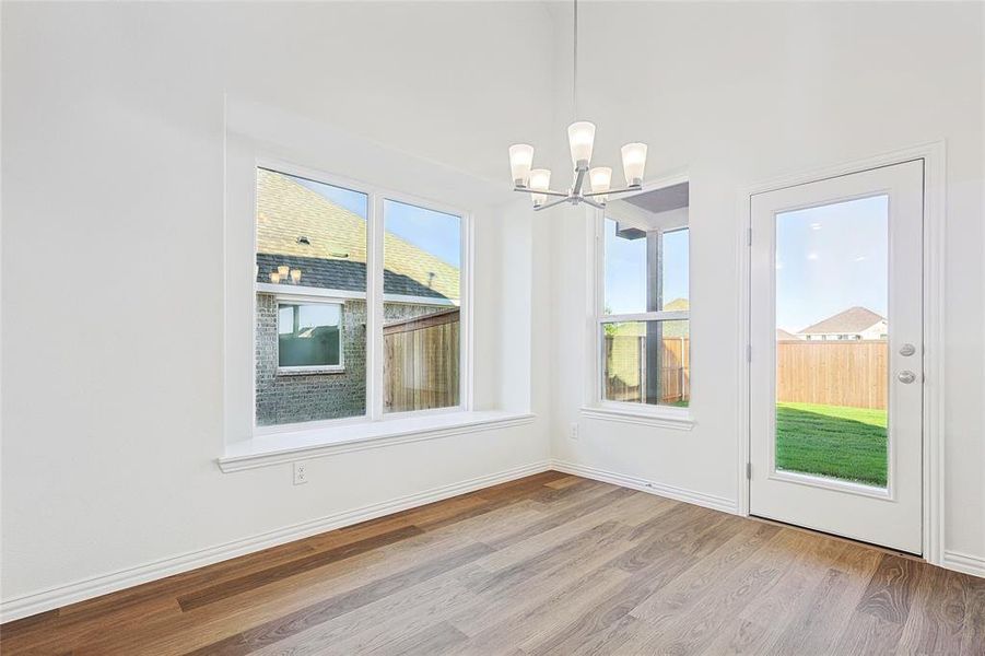 Unfurnished dining area with an inviting chandelier and light wood-type flooring