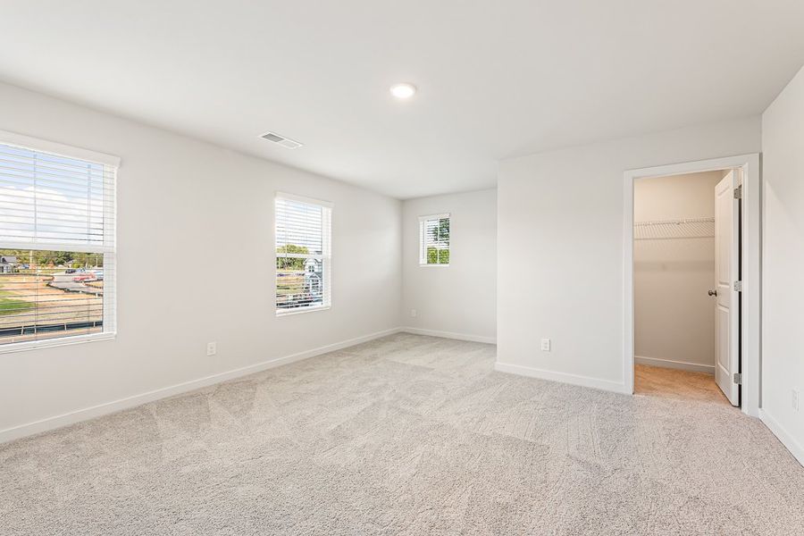 A room with a carpet and windows.