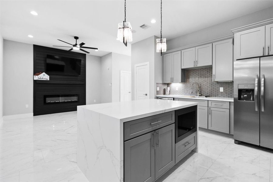 This view captures how effortlessly your kitchen flows into the living space, creating a layout that works just as well for quiet nights in as it does for entertaining. The oversized island, modern cabinetry, and clean lines give you a space that feels expansive, functional, and easy to live in every single day. This view captures how effortlessly your kitchen flows into the living space, creating a layout that works just as well for quiet nights in as it does for entertaining. The oversized island, modern cabinetry, and clean lines give you a space that feels expansive, functional, and easy to live in every single day.