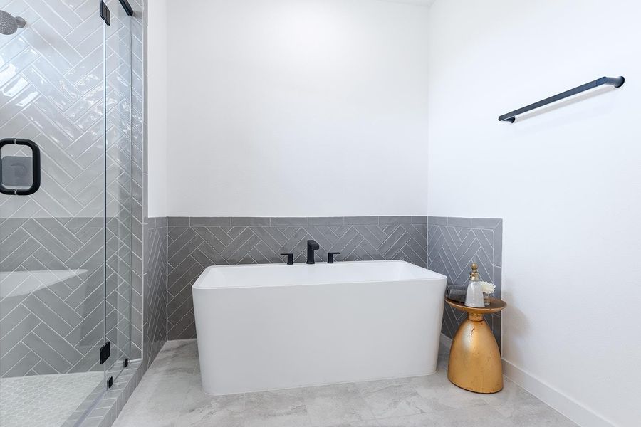 Bathroom featuring a soaking tub, tile walls, and a stall shower